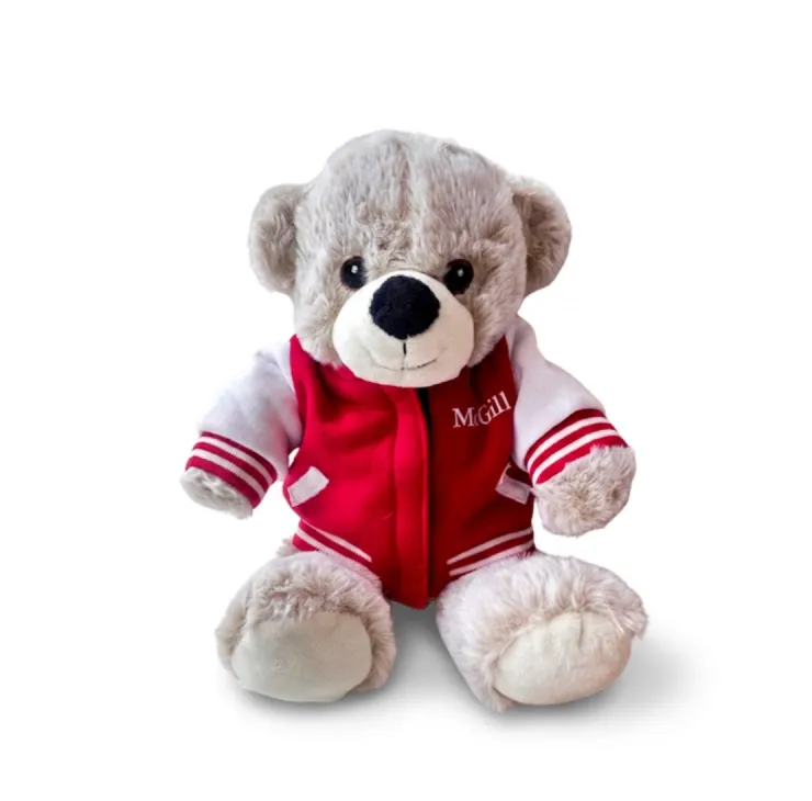 Beige McGill plush teddy bear wearing red varsity jacket with white sleeves and McGill logo on chest.