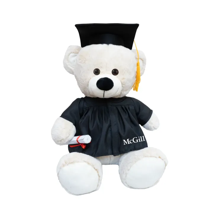 Plush McGill graduation teddy bear wearing black cap and gown and holding a diploma, with McGill logo on robe.