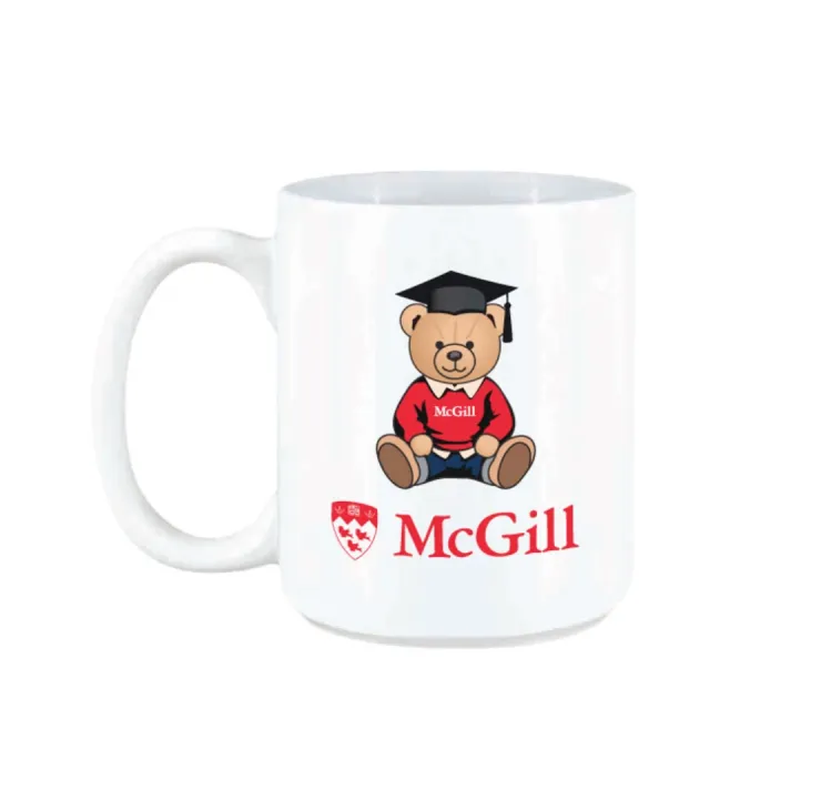 White McGill mug featuring graduation teddy bear graphic wearing cap and gown, with red McGill logo.