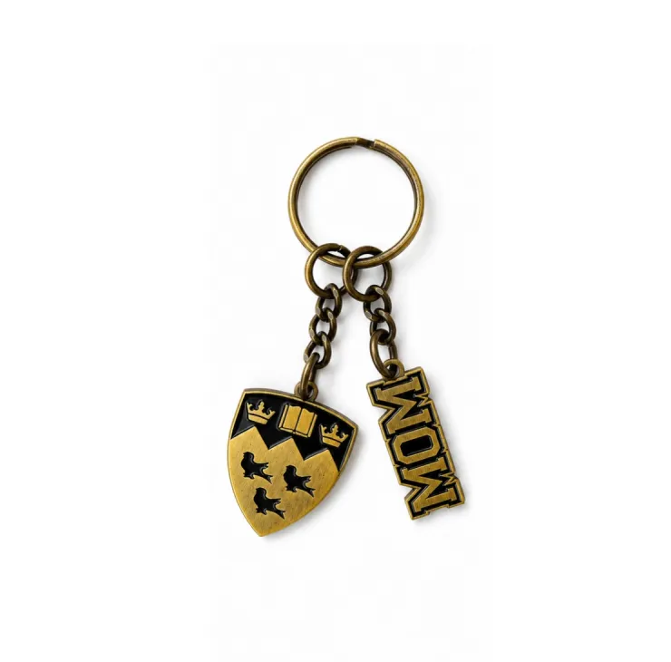 Antique gold tone McGill Mom keychain with embossed crest and “Mom” lettering on chain hardware