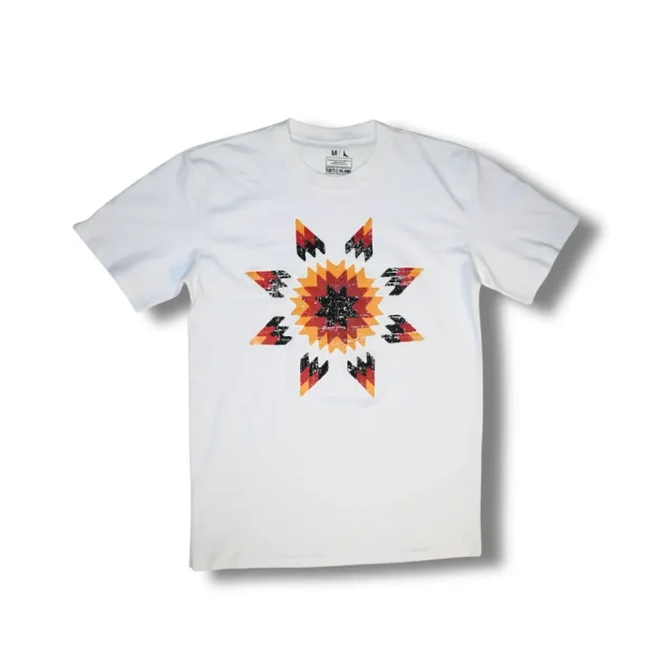 White T‑shirt featuring a multicoloured star blanket–inspired geometric design in orange, red, black, and yellow.