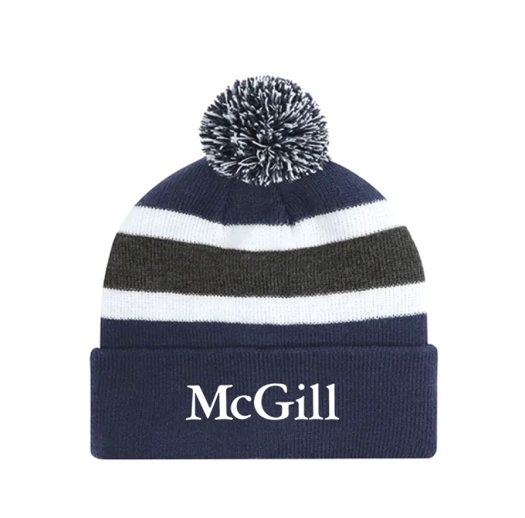 Navy McGill pom‑pom tuque with white and grey stripes, ribbed cuff, and embroidered McGill wordmark.