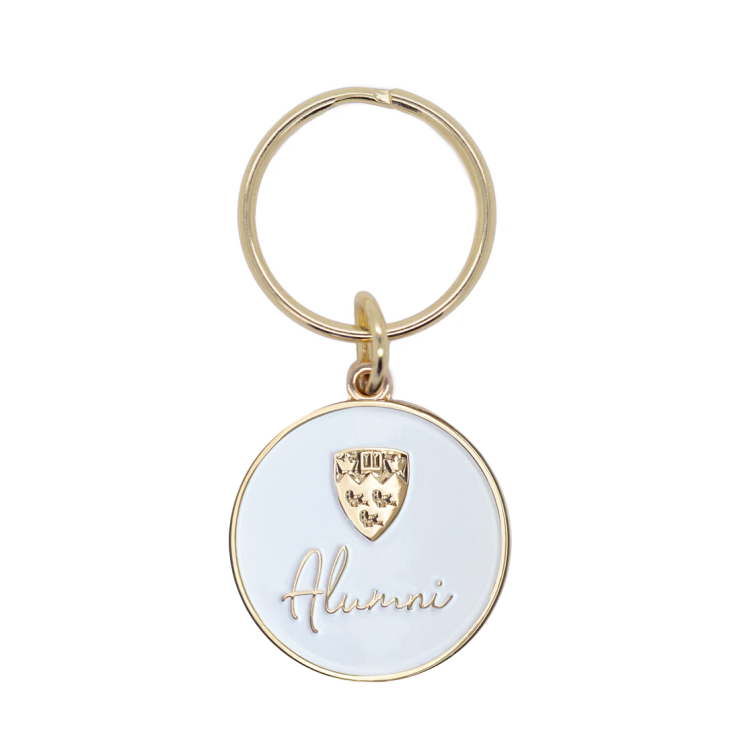 Gold plated brass keychain featuring a McGill crest and "Alumni" embossed in gold and finished with a white enamel fill.