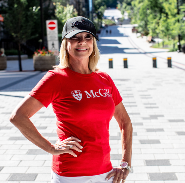Red McGill University t-shirt and black McGill cap worn by model outdoors – official campus merchandise.