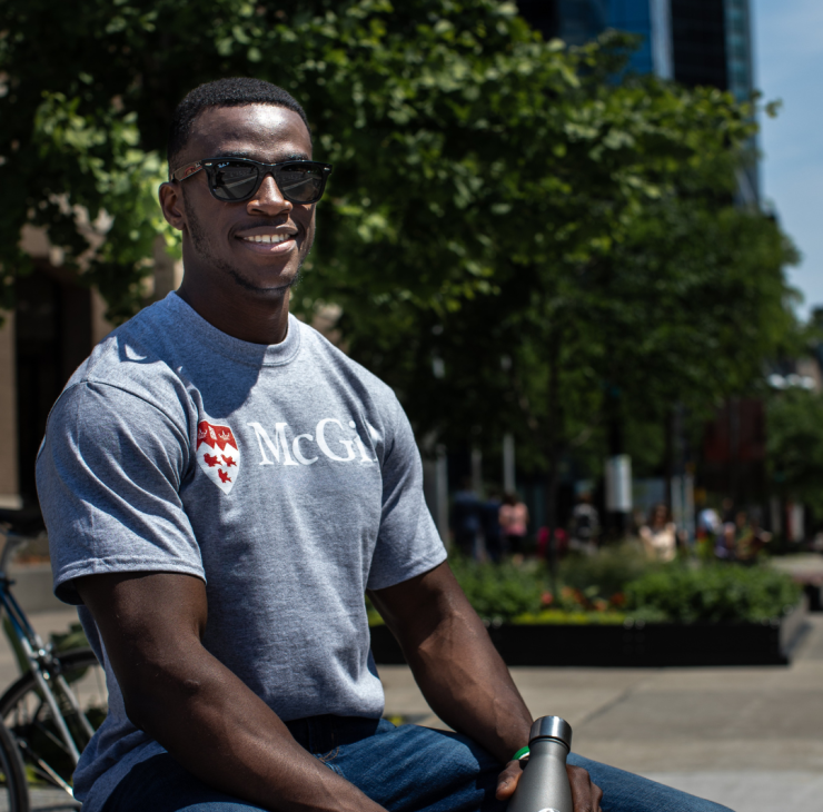 Gray McGill University t-shirt with red crest logo and 'McGill' text – worn by model outdoors, holding black water bottle.