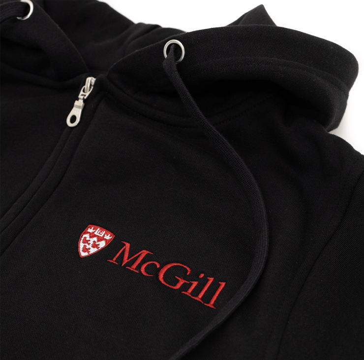 A close up of a black hoodie made from an innovative ultra-smooth fleece featuring a double lined hood and two-toned McGill logo embroidered on the left chest