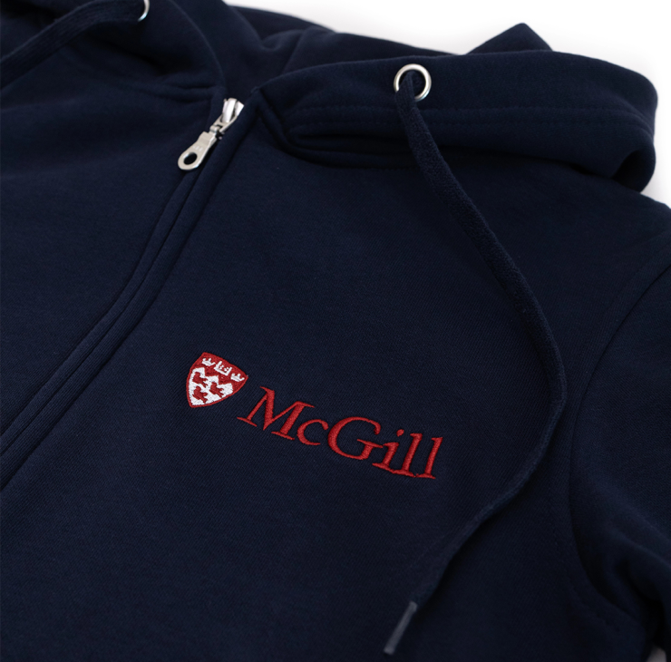 A close up of a navy hoodie made from an innovative ultra-smooth fleece featuring a double lined hood and two-toned McGill logo embroidered on the left chest