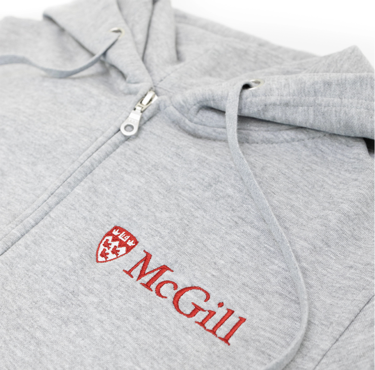 A close up of a light grey hoodie made from an innovative ultra-smooth fleece featuring a double lined hood and two-toned McGill logo embroidered on the left chest