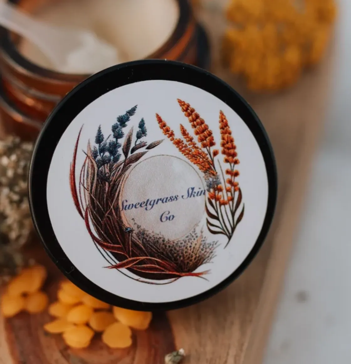 Gatherer Balm moisturizer in amber glass jar with botanical label, shown open with cream balm and applicator scoop.