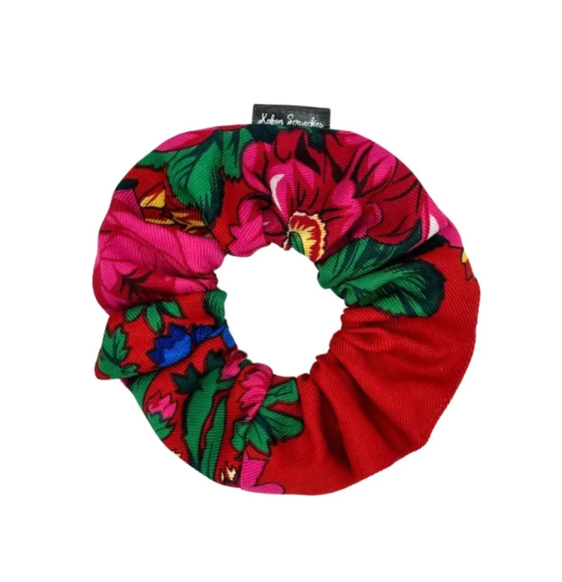 Red floral scrunchie with vibrant pink flowers and green leaves, designed by Kokom Scrunchies.