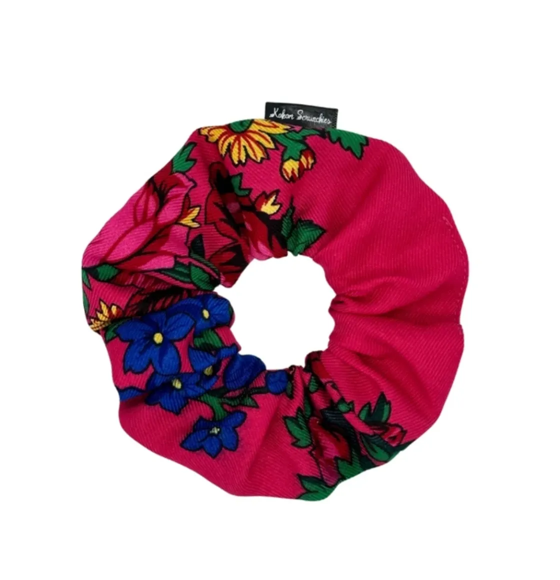 Pink floral scrunchie with vibrant yellow and blue flowers and green leaves, designed by Kokom Scrunchies.