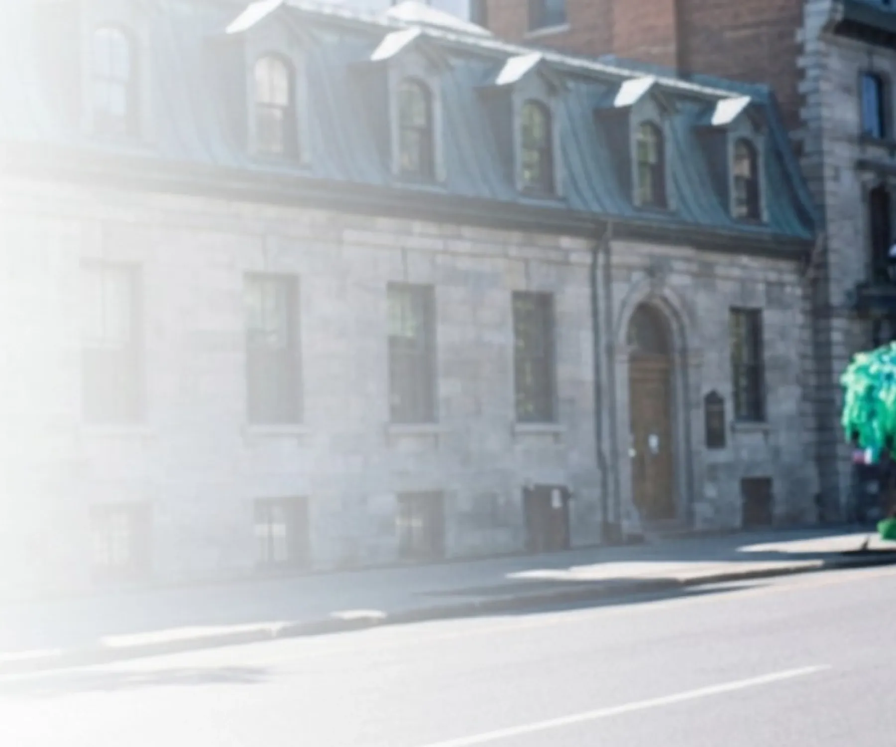 Student wearing a white McGill T-shirt on campus with historic university buildings in the background.